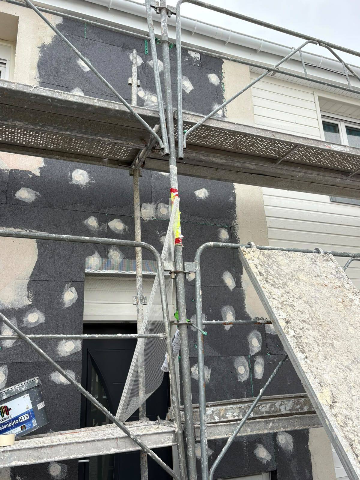 Isolant chevillé derrière l’échafaudage