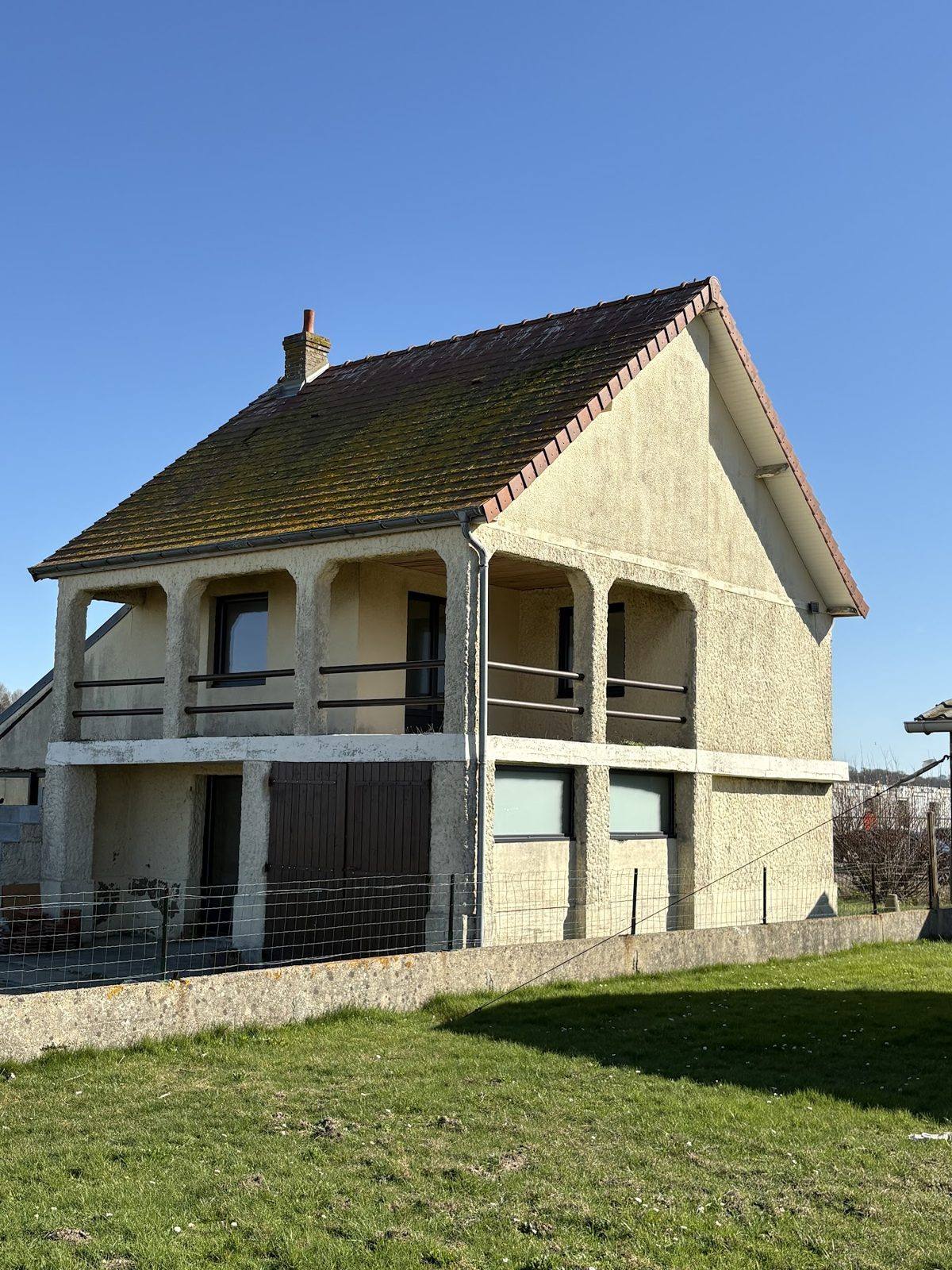 Maison avec toiture en tuiles et balcon